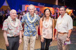 A group of four pose for a photograph at an event.