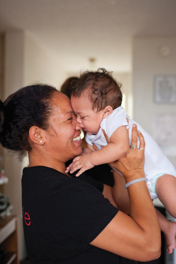 Woman smiling and cuddling a baby