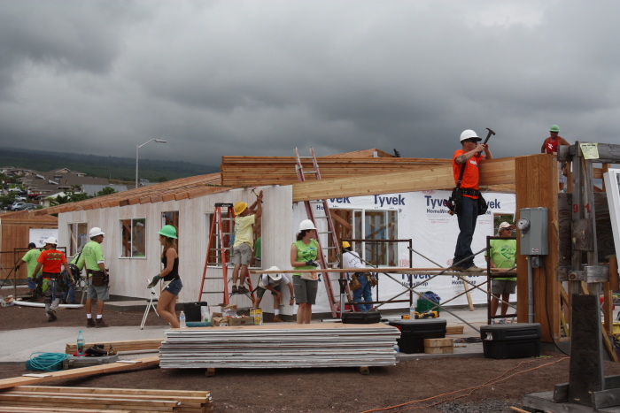 A group of Habitat for Humanity Maui volunteers actively building a house