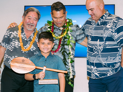 At the 2022 Ho‘okele Awards, HCF CEO and president Micah Kāne, at far right, joins previous HCF CEO and president Kelvin Taketa, at far left, with Ho‘okele awardee Chad Cabral, of the Boys & Girls Club of the Big Island.