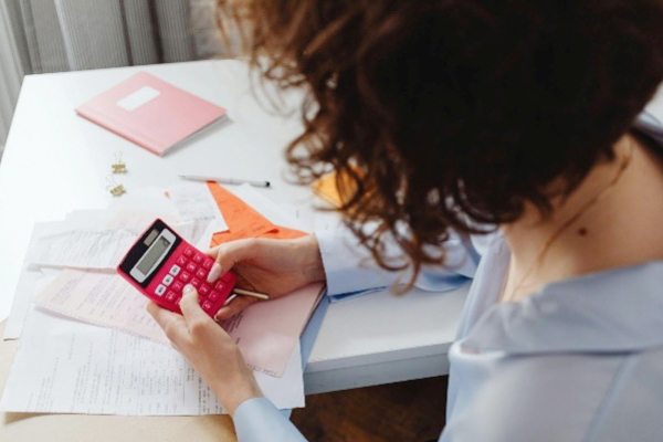 A woman holding a calculator doing financial planning