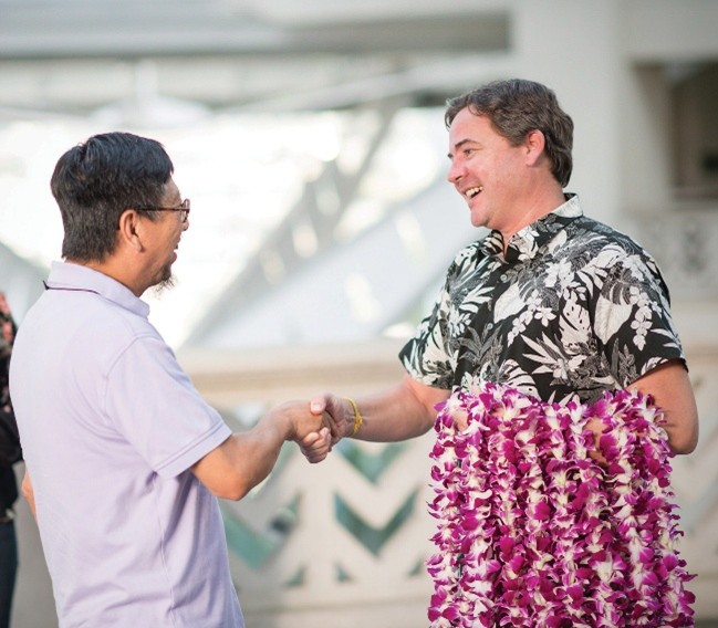 Two men smiling and shaking hands